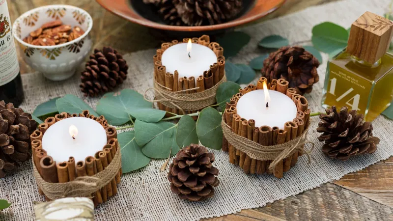Candele per decoro tavola di Natale con cannella e pigne