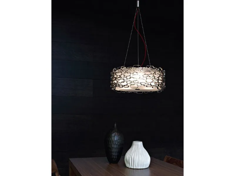 lampadario con fascia di anelli metallici, due vasi nero e bianco su tavolo in legno