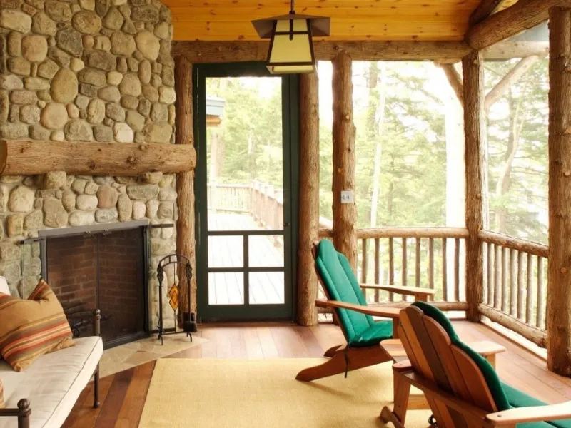 Veranda con camino arredata in stile rustico