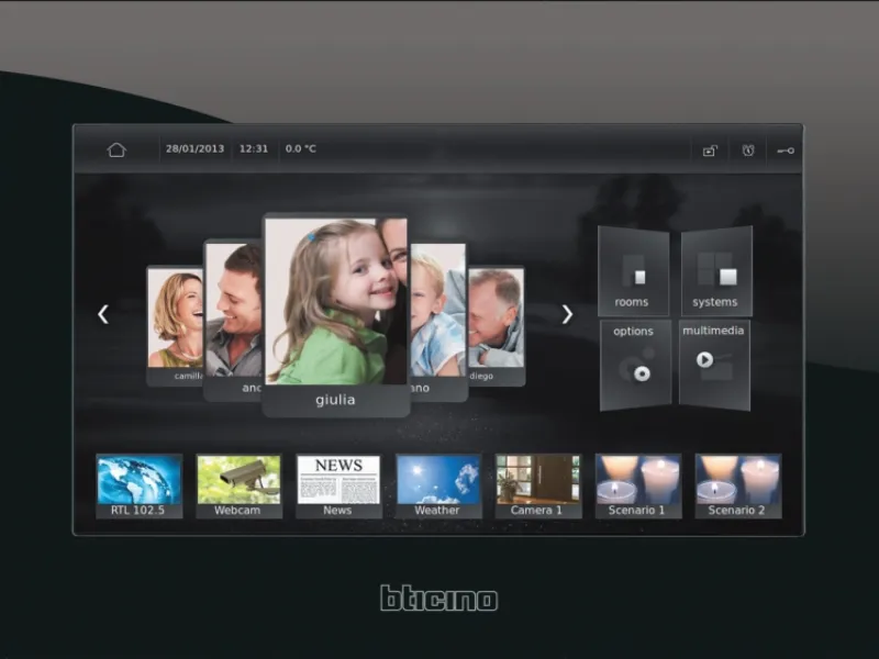 Pannello touch screen con cornice nera montato su parete, cucina sullo sfondo