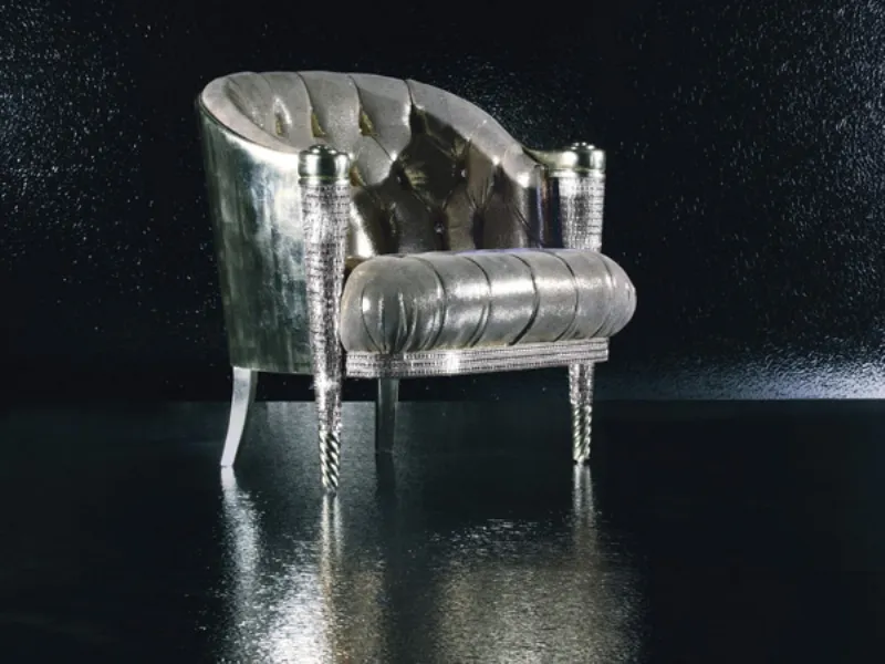 Poltroncina con cuscino trapuntato e colori della struttura in legno e del rivestimento metallici