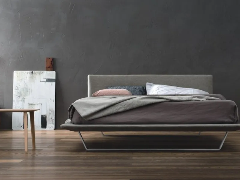 camera da letto con parete grigio scuro e letto Omar Doimo
