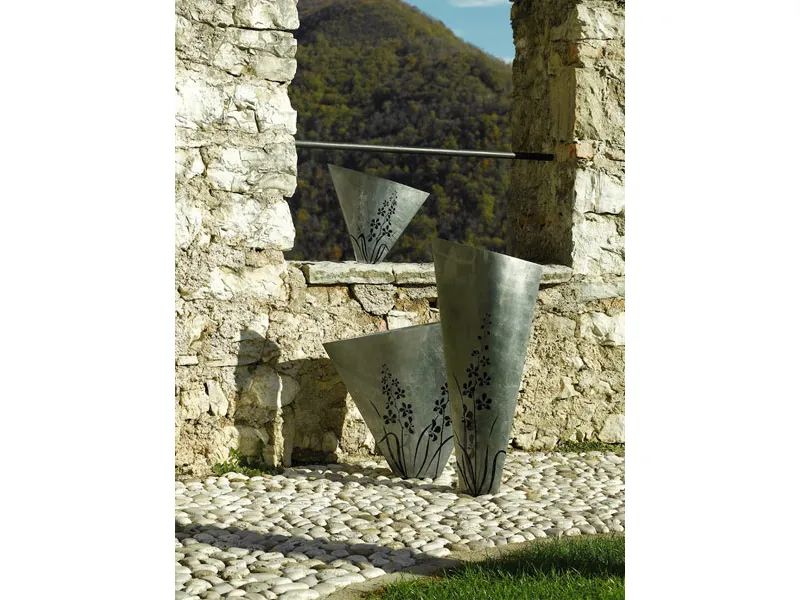 tre vasi in legno color argento con decorazioni floreali viola su muro a secco