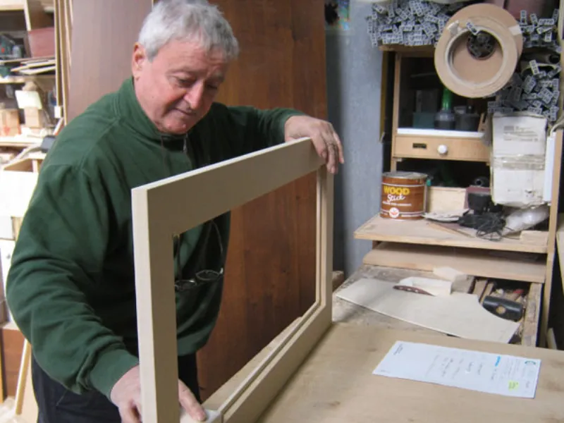 uomo in laboratorio con cornice in legno