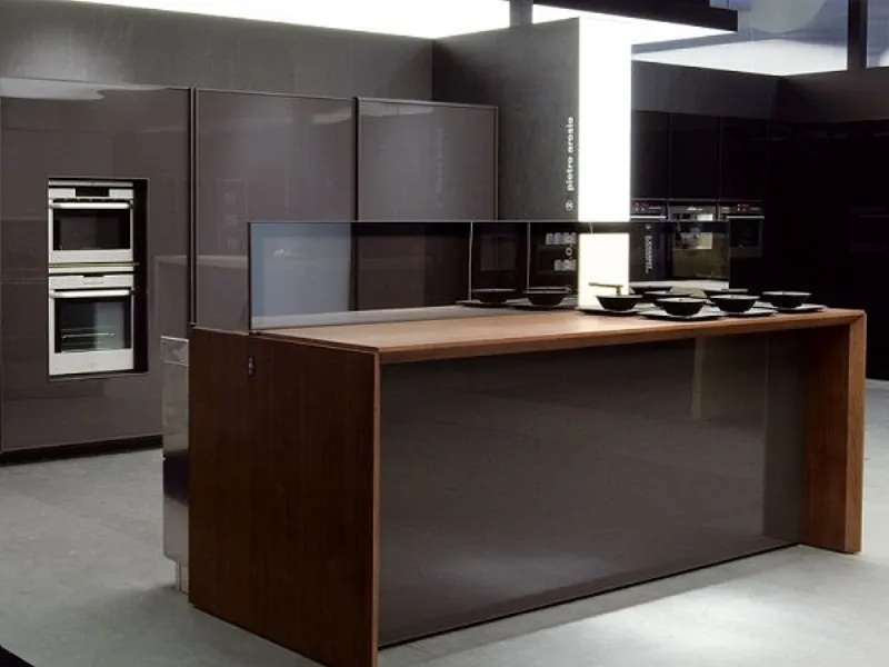 banco cucina a isola in legno di due tonalità, sullo sfondo pareti cucina per spazio espositivo