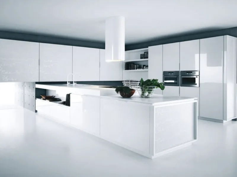 cucina con isola centrale e mobili squadrati e cappa curvilinee, tutto in bianco