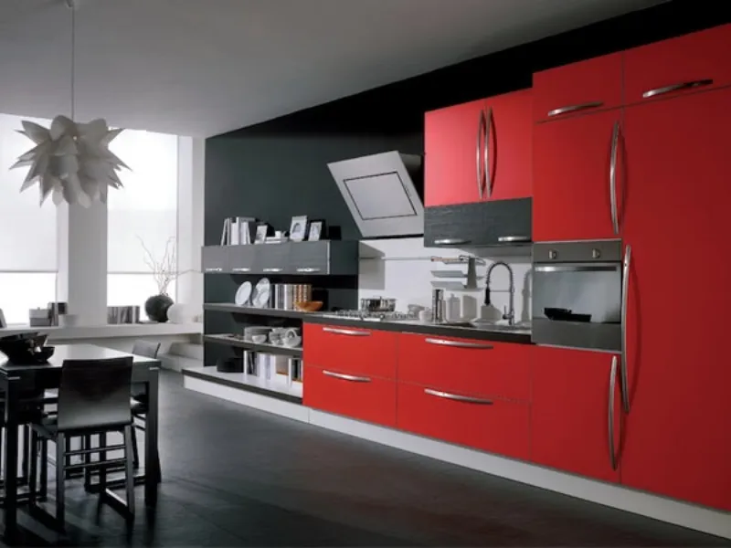 mobili cucina a parete rossi e in legno nero, dettagli in acciaio, tavolo con sedie in legno nero, lampadari desgin bianco