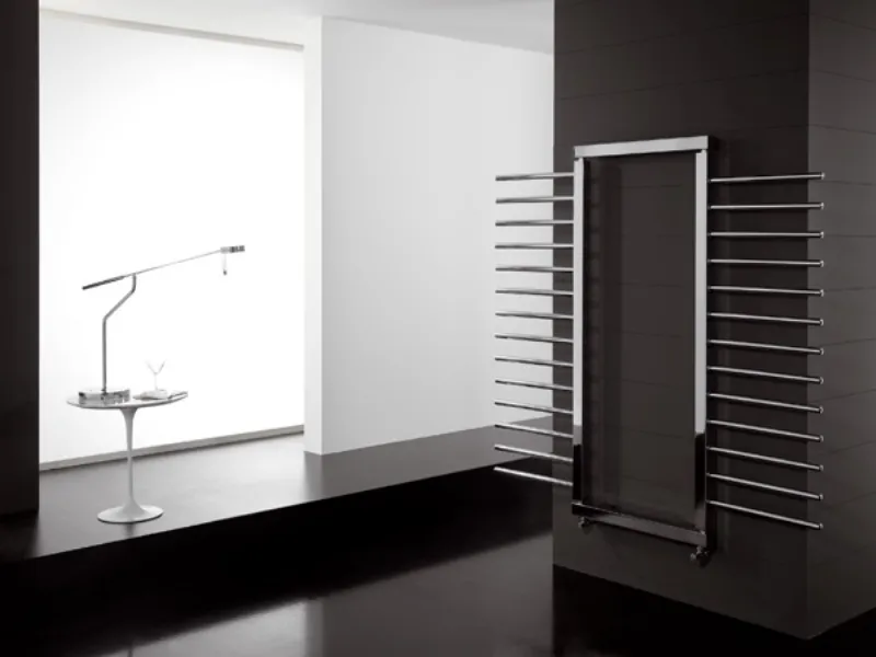 radiatore da parete con cornice e tubi radianti paralleli laterali, tavolino bianco con lampada da tavolo