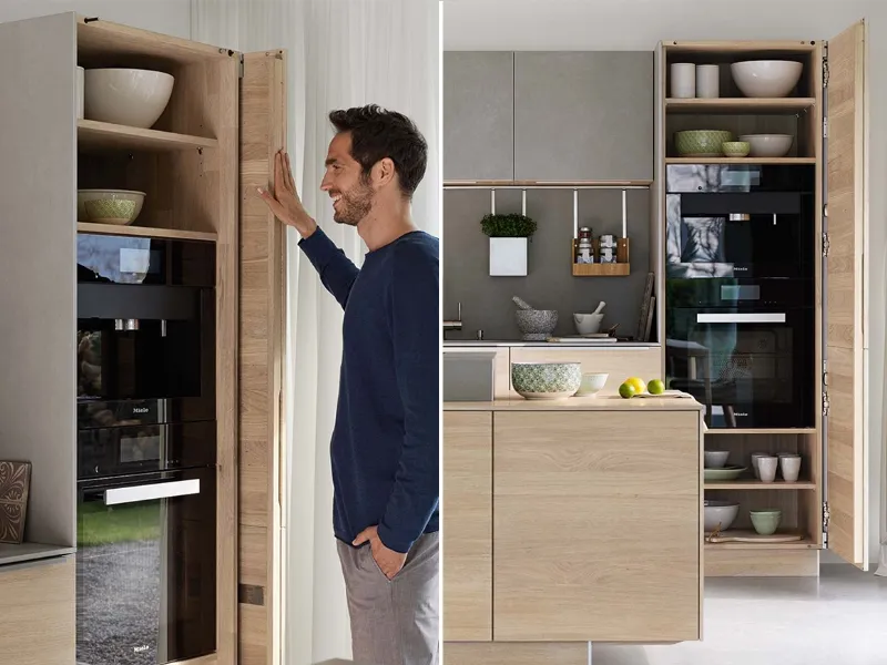 Team 7 e la cucina Filigno in legno naturale dotata di armadi con ante girevoli e rientranti per un perfetto accesso agli elettrodomestici