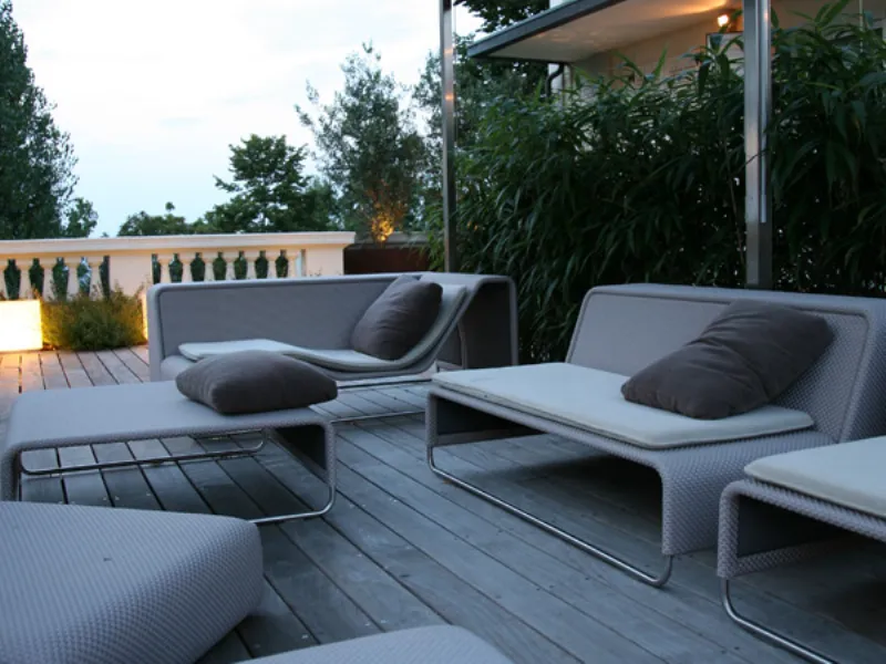 veduta su terrazzo con parquet e gazebo, divani, pouf e tavolino design bianchi con cuscini marroni