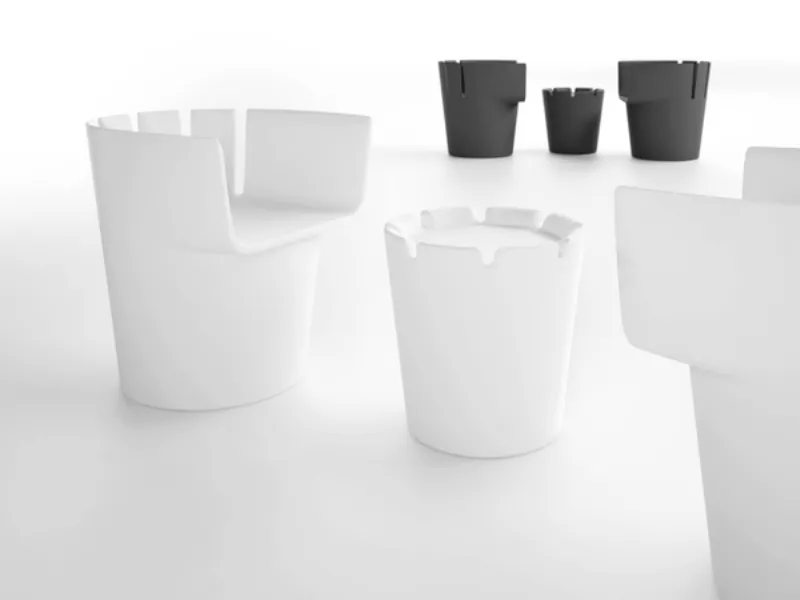 tavolino e due poltrone design bianche, sullo sfondo di colore antracite