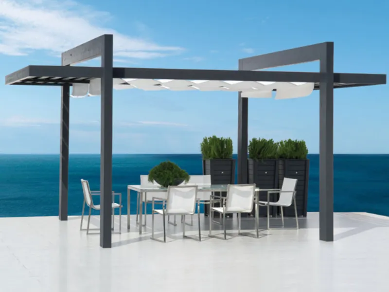 Gazebo con tavolo e sedie vicino al mare