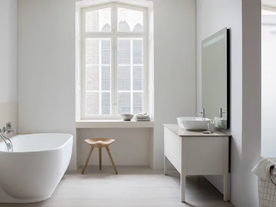 Serie Luv di Duravit. Bagno con vasca appoggiata al muro e console in legno con lavamani