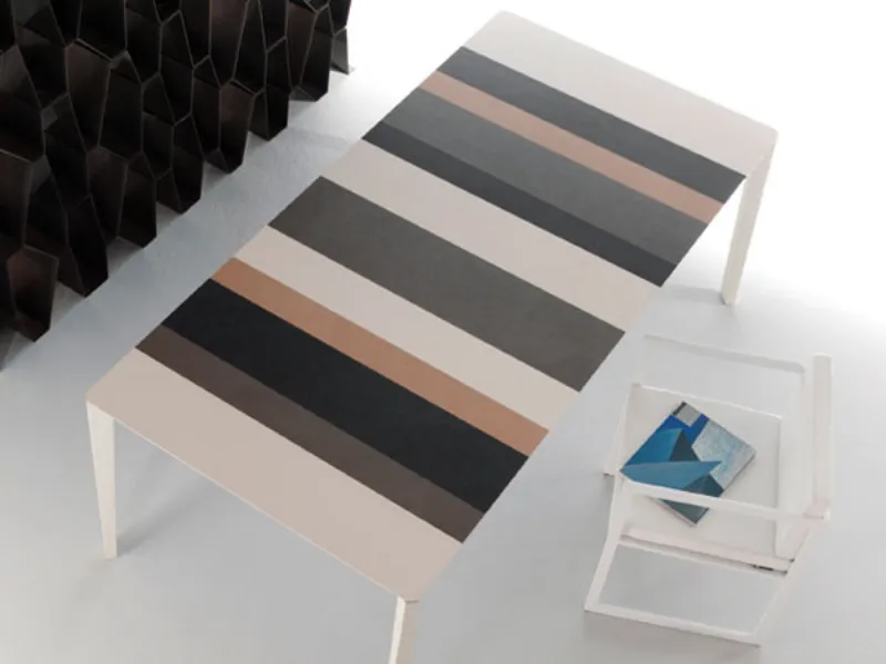 veduta dall'alto di tavolo con piano a righe in toni neutri, sedia design geometrica bianca