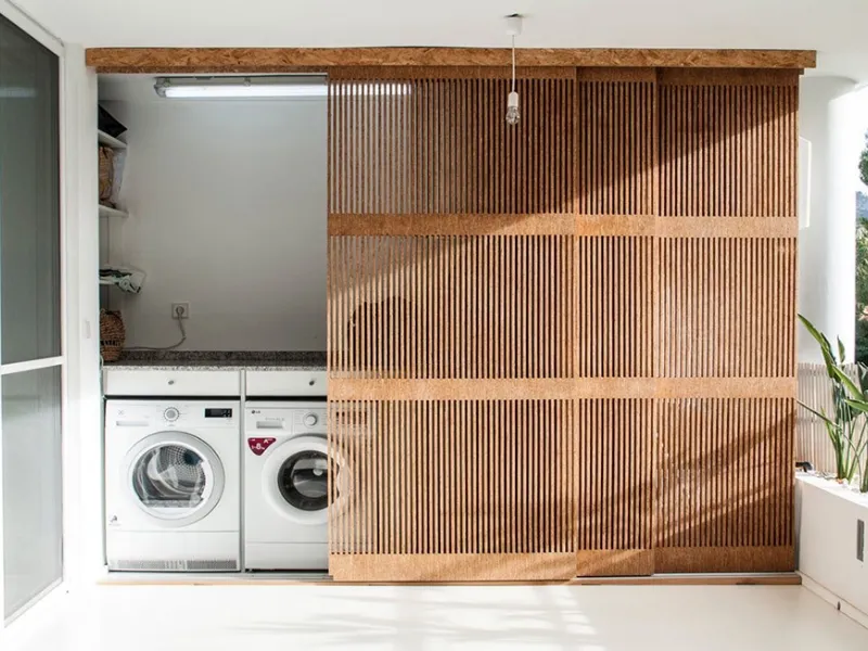 Soluzione progettuale per ricavare spazio lavatrice in balcone con parete arredo in legno