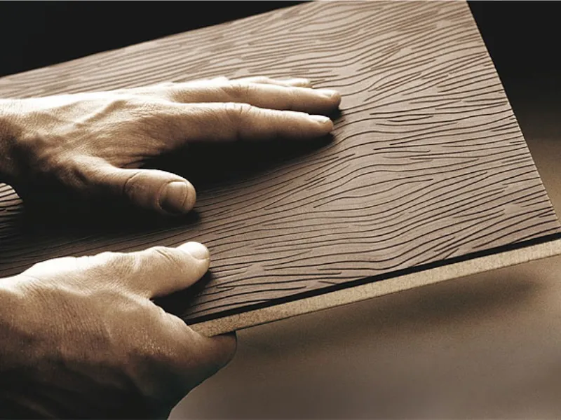 mani con piastrella rivestita in pelle con striature effetto legno