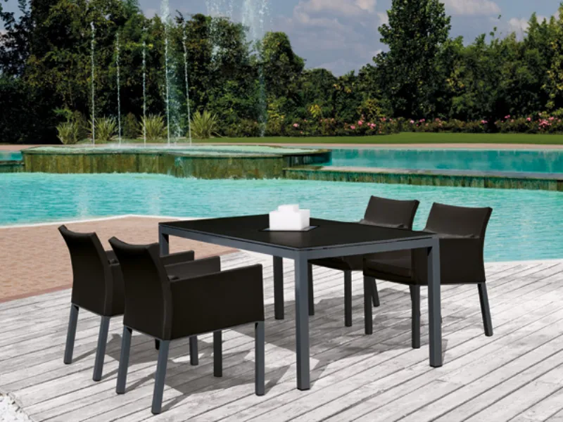 tavolo con quattro sedie abbiate, colore nero in esterno su piscina