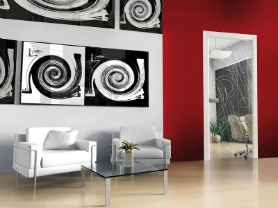 zona living con quadri astratti bianchi e neri su pareti rosse, tavolino in vetro trasparente, due poltrone bianche, porta trasparente con grafiche bianche