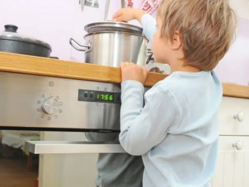 Bambino che tocca una pentola sul fuoco