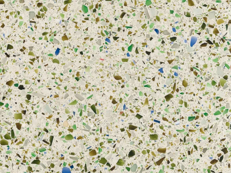 lastra con pagliuzze di vetro verdi, marroni e blu su sfondo beige