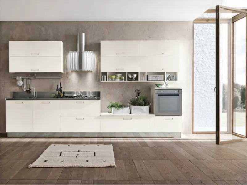 cucina in legno e acciaio con dettagli a specchio su armadiatura, isola centrale con lavabo, piano cottura, piano di lavoro e tavolo snack con due sgabelli