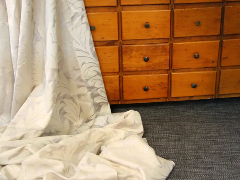 Cassettiera in legno con tenda adagiata sopra