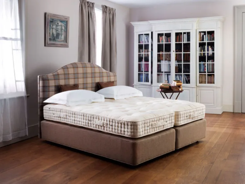 Letto con testata imbottita a fantasia in camera da letto luminosa